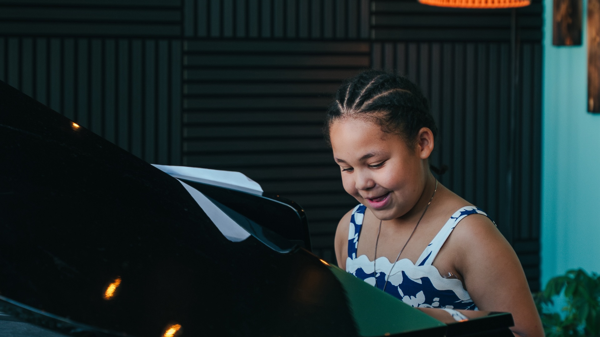 Young student seated at a grand piano during a piano lesson at Resonate in Edmonton