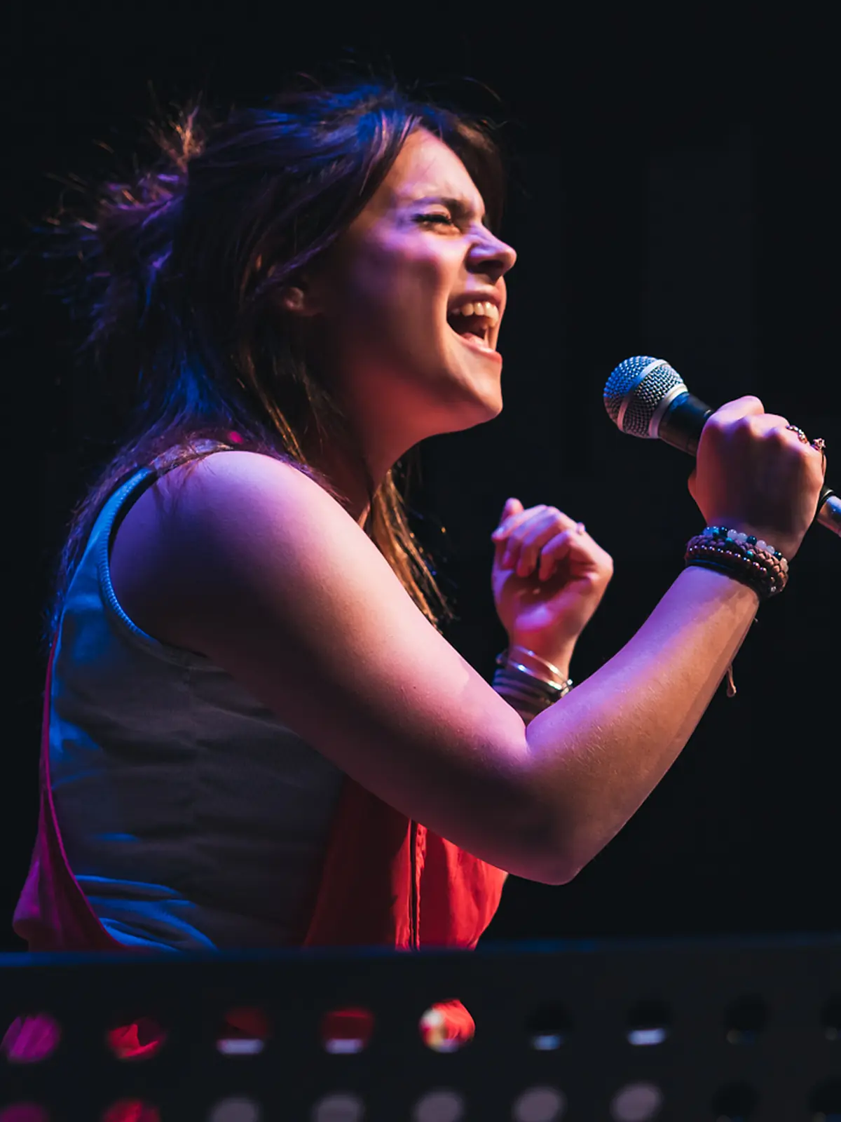 Vocalist performing at the front of a band on the Resonate stage in Edmonton