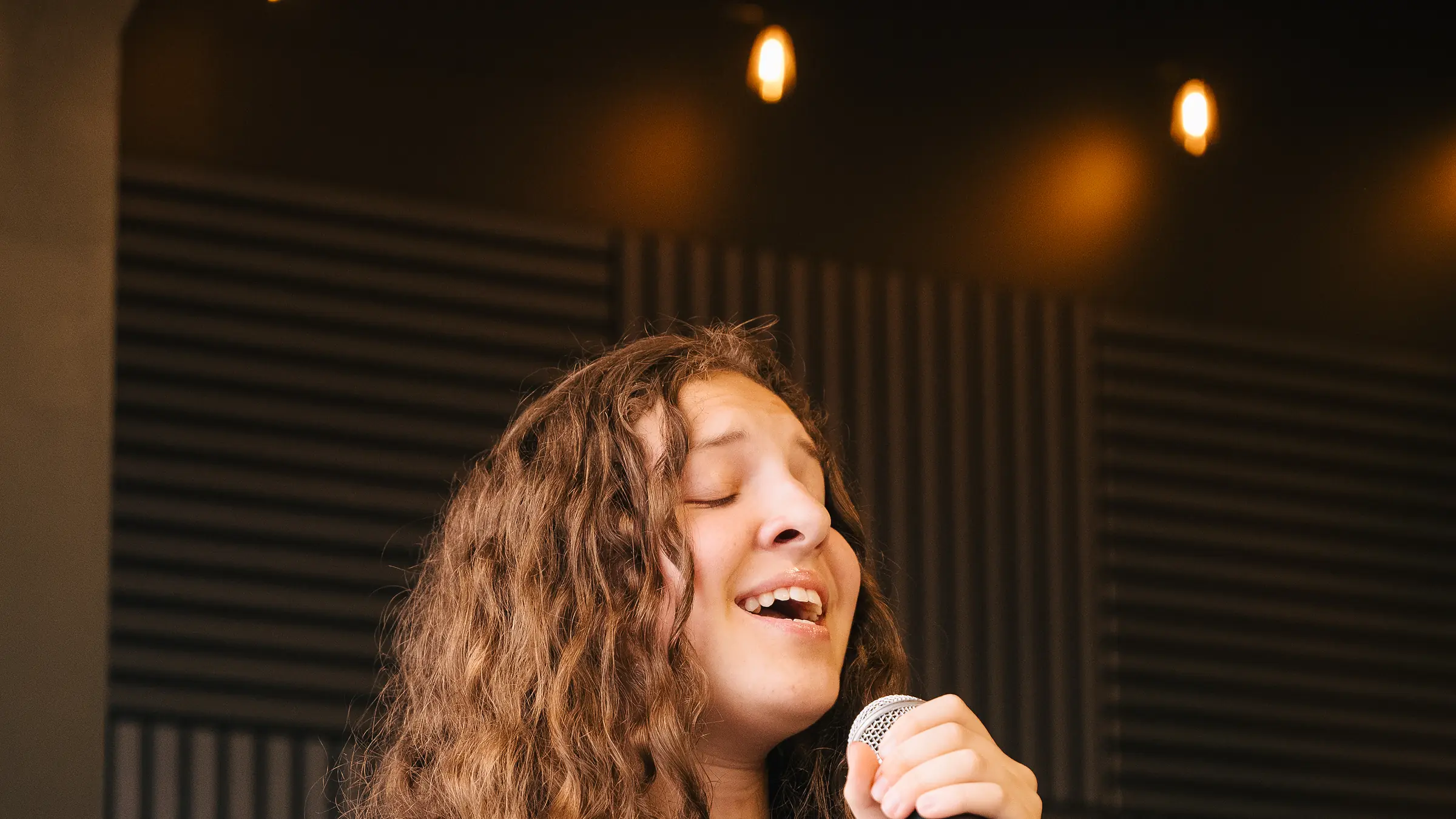 Young singer at the microphone during a vocal performance at Resonate in Edmonton